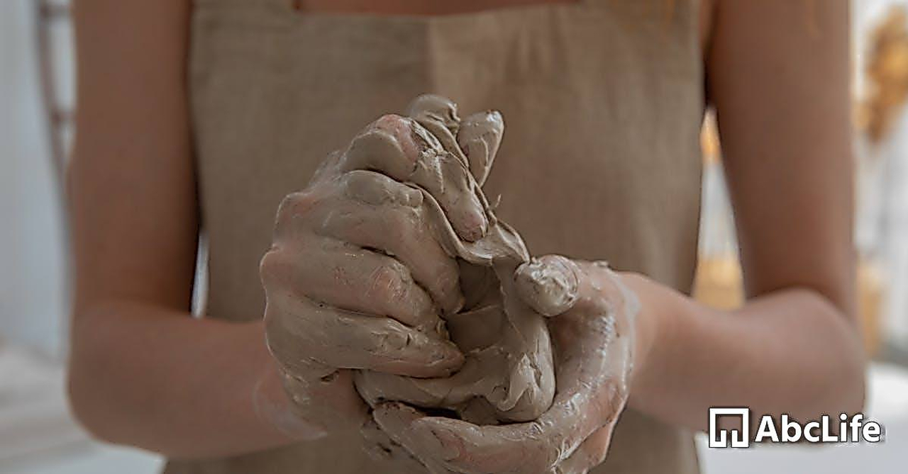 Crop faceless woman kneading clay in workshop