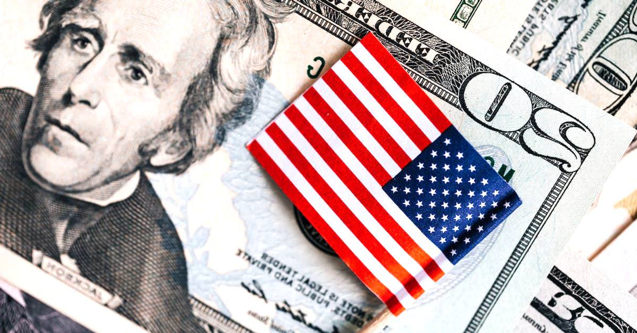 From above of small American flag placed on stack of 20 dollar bills as national currency for business financial operations